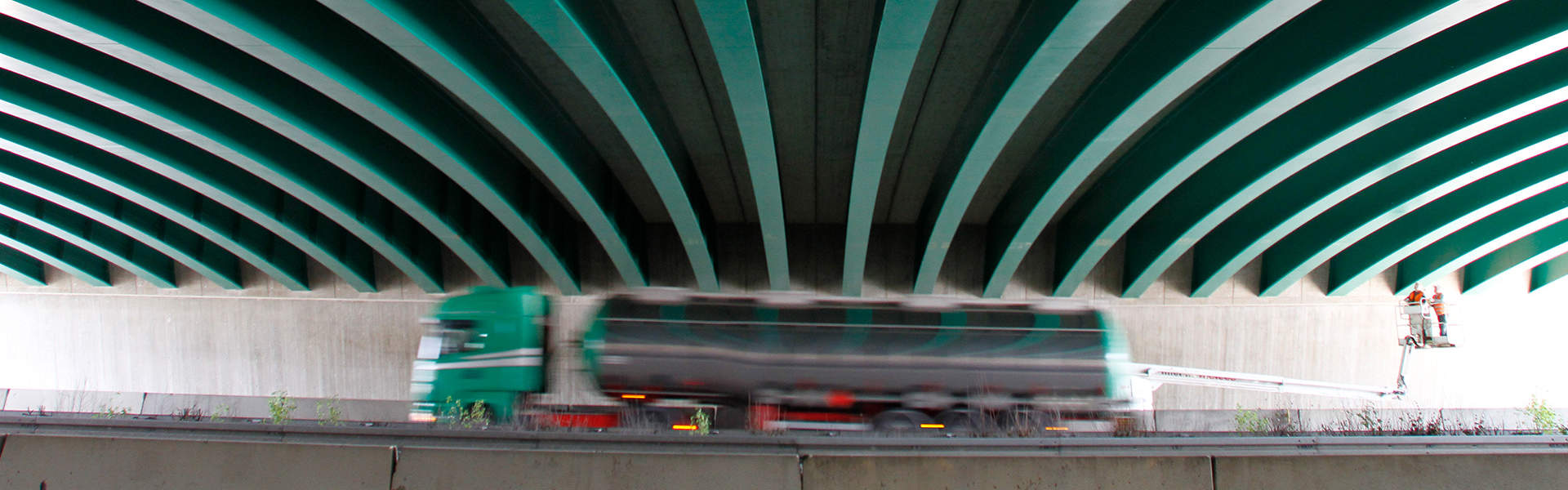 LKW fährt unter einer Brücke